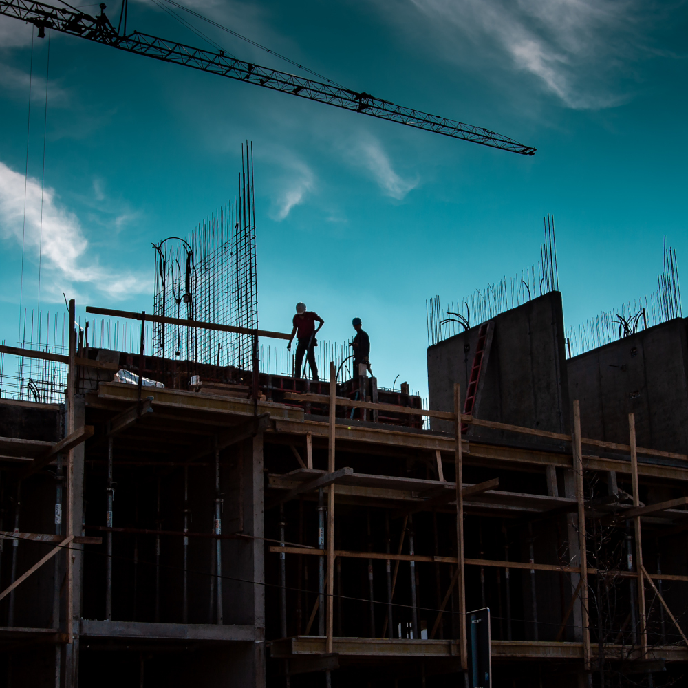 Image of two construction workers on building taken from ground level