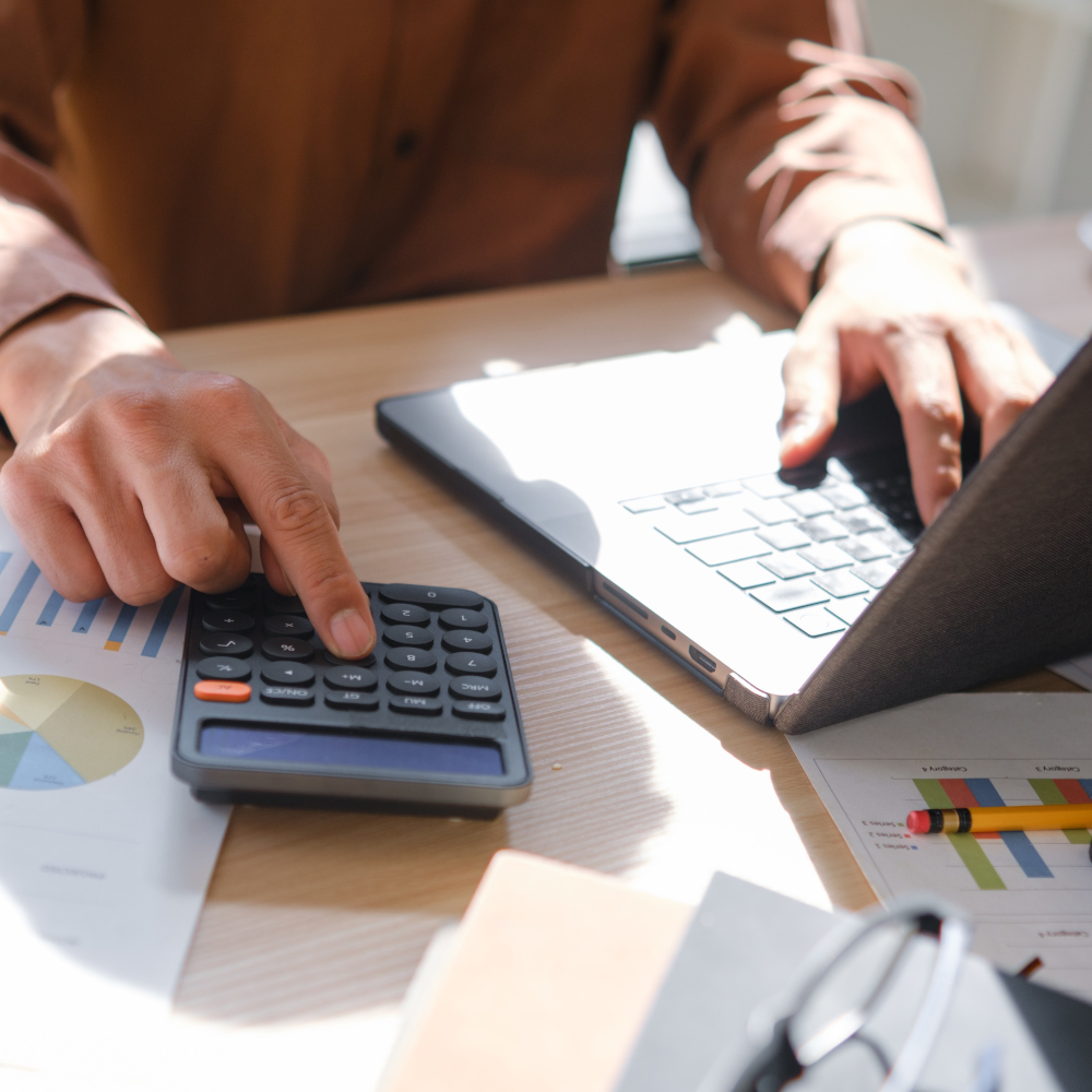 Person types on laptop and calculator