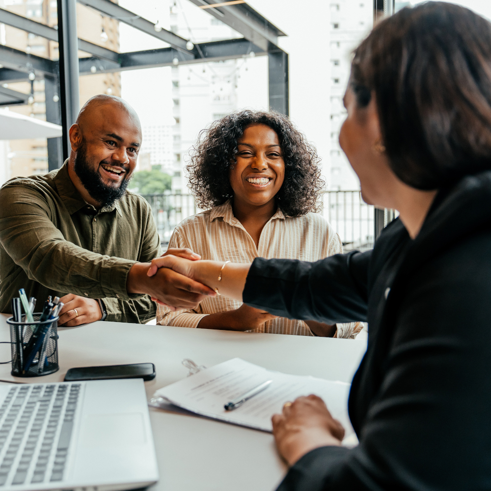 Man reaches over table to shake hands with woman
